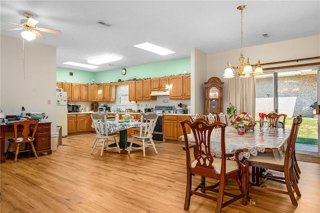 dining area featuring plenty of natural light, ceiling fan with notable chandelier, and light wood-type flooring