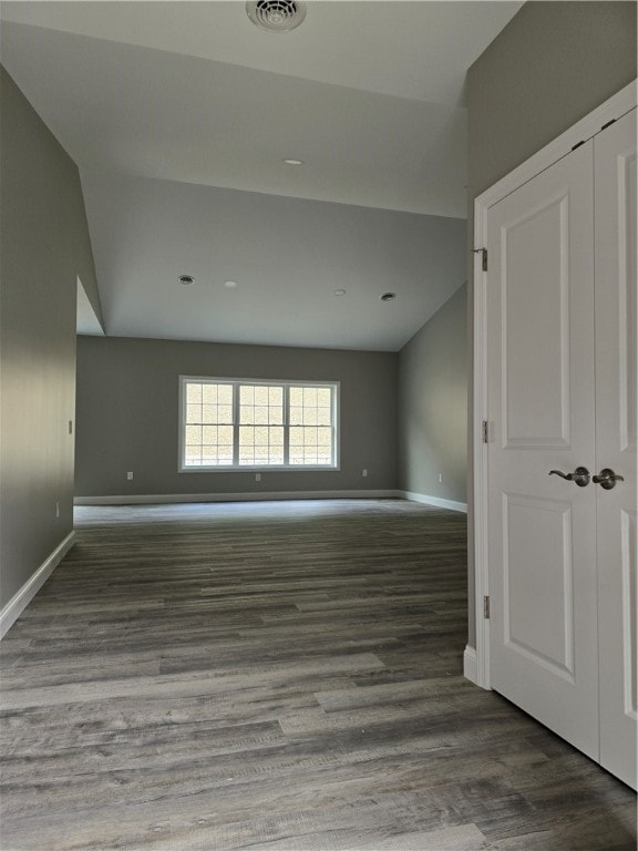 unfurnished room featuring wood-type flooring and vaulted ceiling