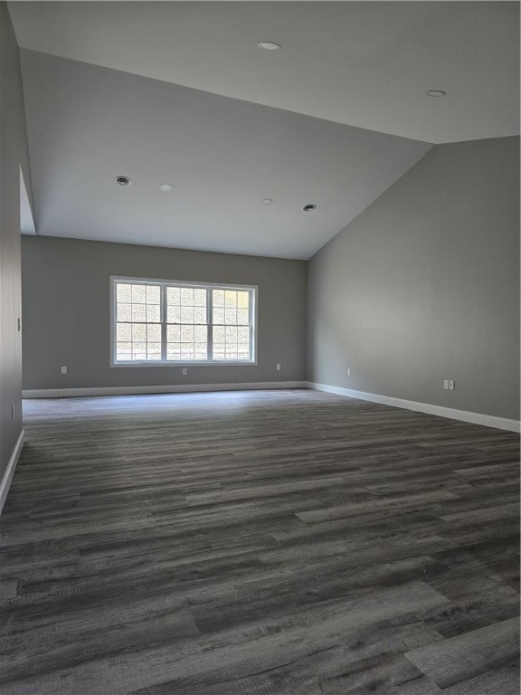 unfurnished room featuring dark hardwood / wood-style flooring and vaulted ceiling