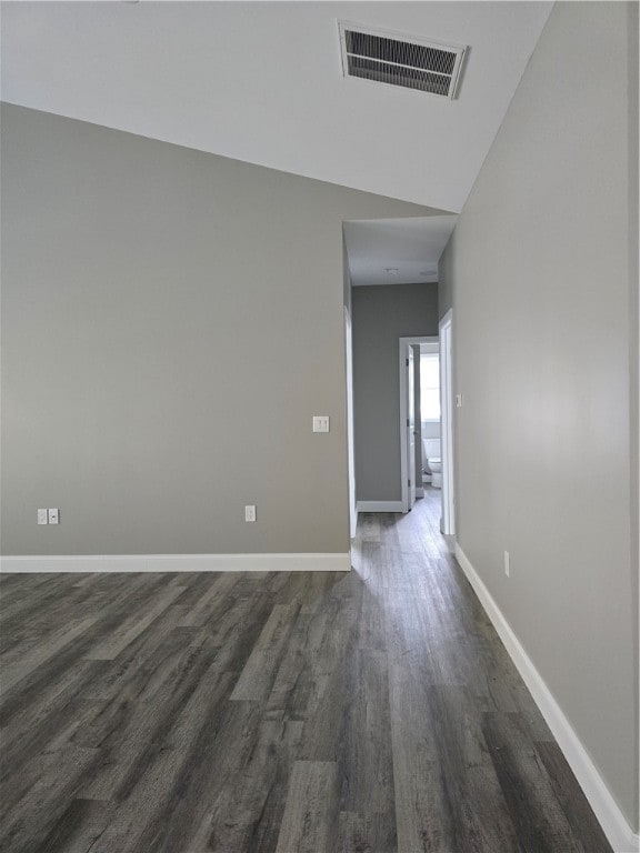 empty room with wood-type flooring and vaulted ceiling