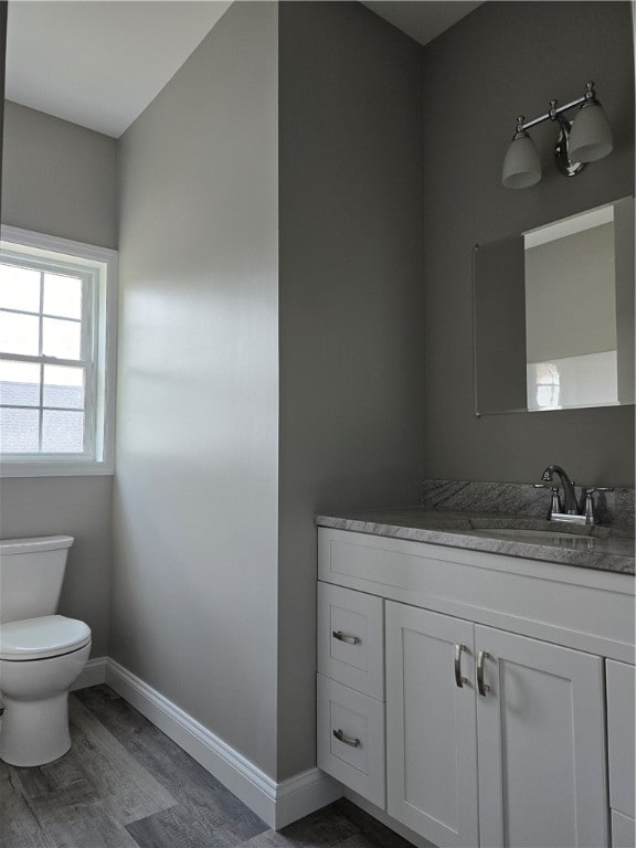 bathroom featuring hardwood / wood-style floors, toilet, and vanity