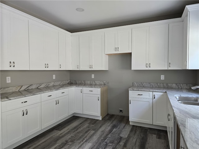 kitchen featuring sink, dark hardwood / wood-style flooring, white cabinets, and light stone counters