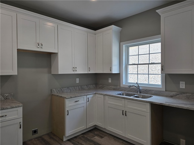 kitchen featuring sink, light stone countertops, white cabinets, and dark wood-type flooring