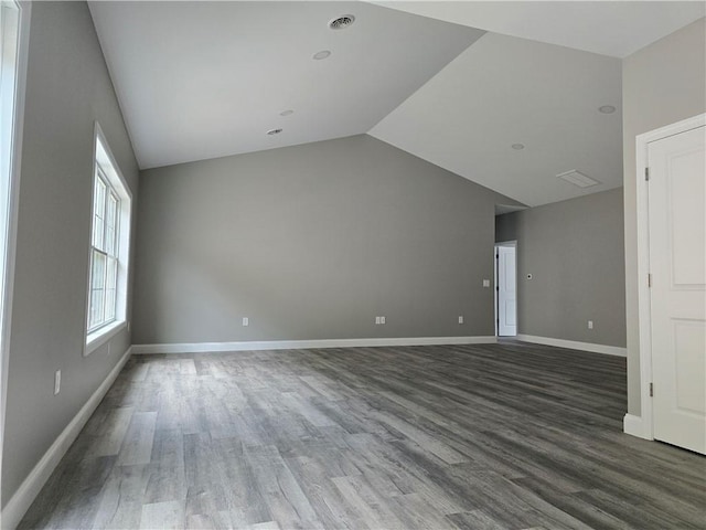 empty room featuring lofted ceiling and dark wood-type flooring