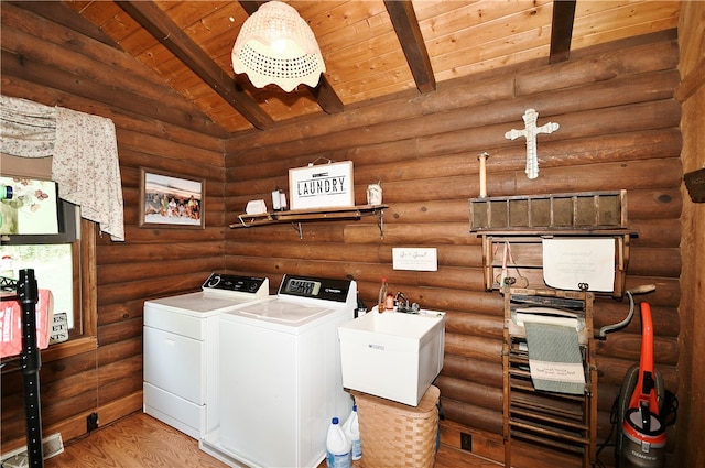 clothes washing area featuring rustic walls, hardwood / wood-style floors, wooden ceiling, and washer and clothes dryer