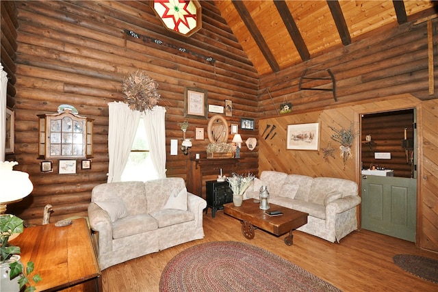 living room featuring hardwood / wood-style floors, high vaulted ceiling, log walls, beamed ceiling, and wooden ceiling