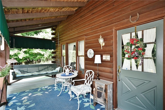 exterior space with rustic walls, vaulted ceiling with beams, wooden ceiling, and hardwood / wood-style flooring