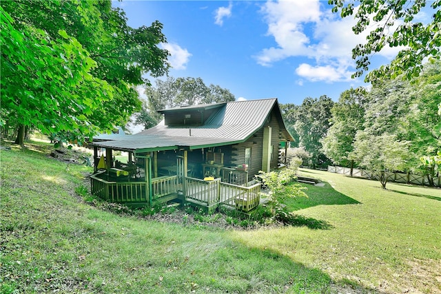 rear view of house featuring a deck and a lawn