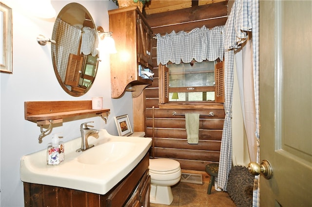 bathroom with toilet, vanity, and tile patterned floors