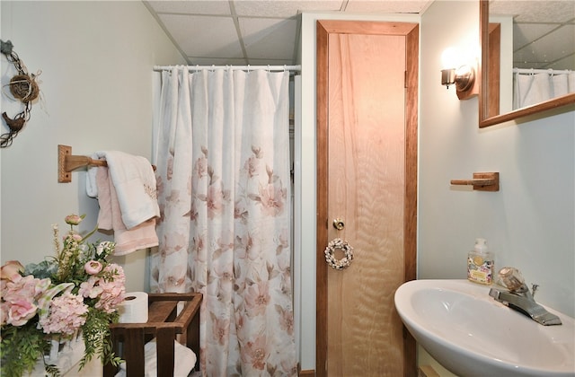 bathroom featuring a drop ceiling and sink