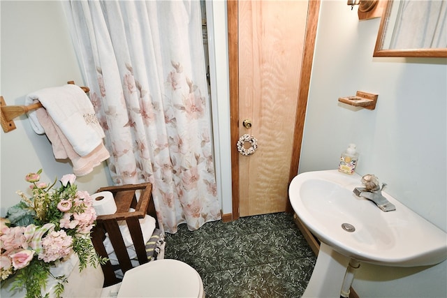 bathroom with sink, toilet, and tile patterned flooring