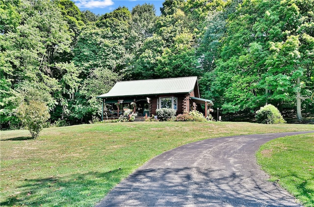 log-style house with a porch and a front yard