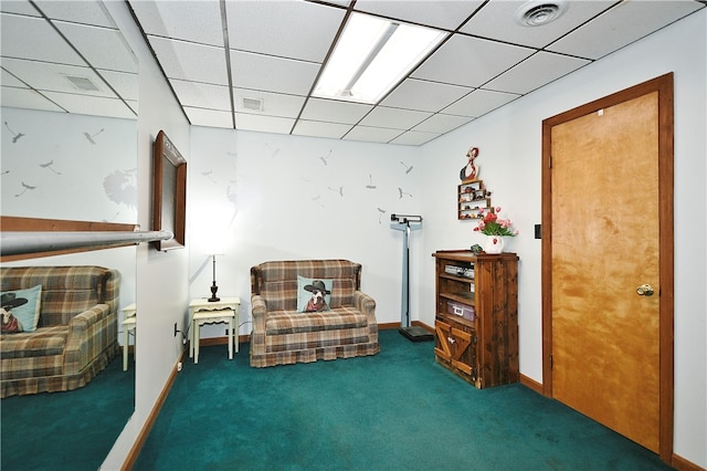 living area featuring carpet flooring and a paneled ceiling