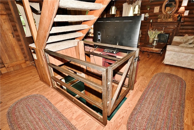 stairs featuring hardwood / wood-style flooring and log walls