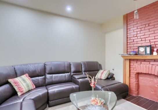 living room with a brick fireplace and brick wall