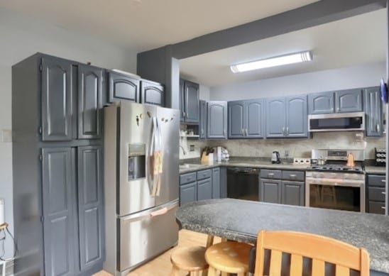 kitchen with appliances with stainless steel finishes, tasteful backsplash, sink, and a kitchen breakfast bar