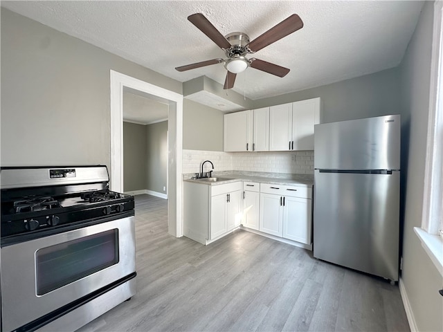 kitchen with ceiling fan, stainless steel appliances, light wood-type flooring, sink, and backsplash