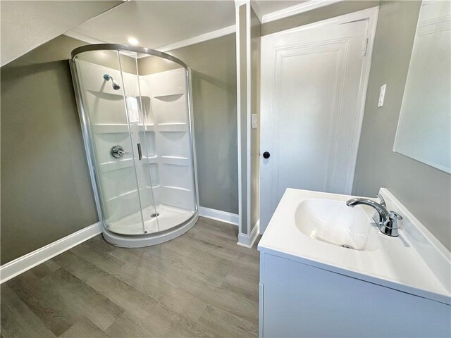 bathroom with hardwood / wood-style floors, vanity, and walk in shower