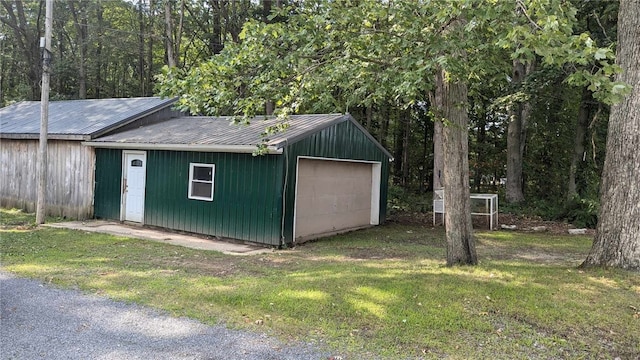 view of outdoor structure featuring a garage and a lawn