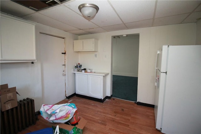 814 Etna St, Mckees Rocks, PA 15136 - kitchen featuring freestanding refrigerator, radiator heating unit, a drop ceiling, wood finished floors, and white cabinets