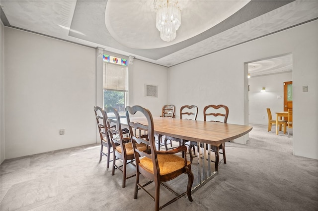 carpeted dining area with a raised ceiling and an inviting chandelier