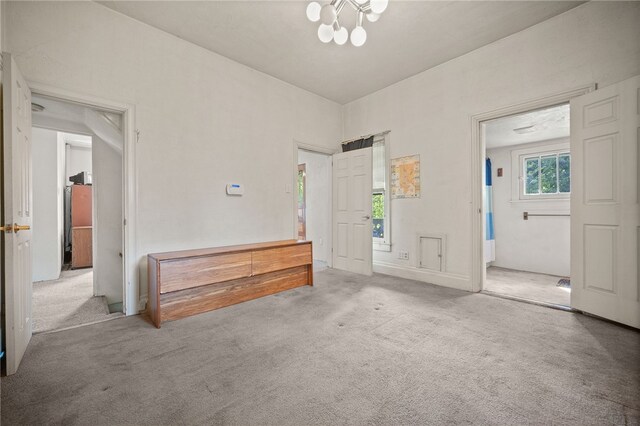 interior space featuring light carpet and a chandelier