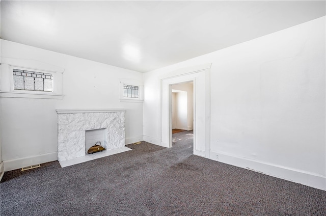 unfurnished living room with a fireplace and carpet floors