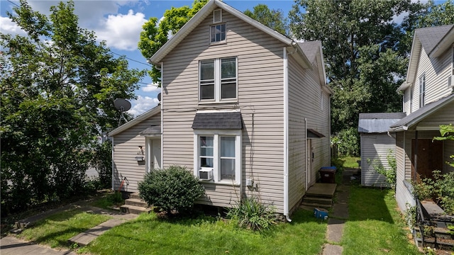 view of front of house with cooling unit and a front yard