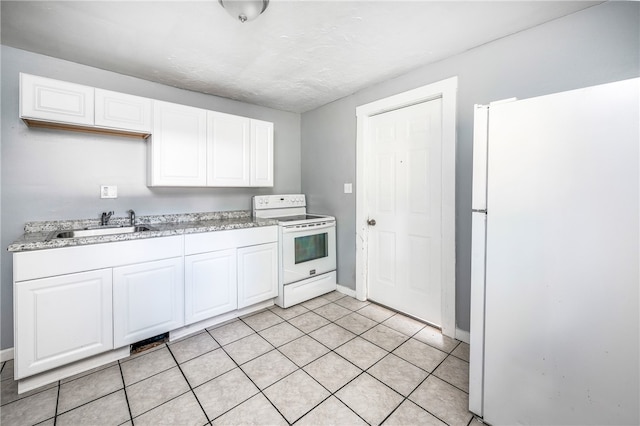 kitchen featuring light tile patterned flooring, white cabinetry, white appliances, and sink