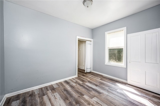 unfurnished bedroom with hardwood / wood-style flooring and a closet