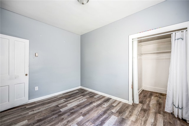 unfurnished bedroom featuring a closet and hardwood / wood-style floors