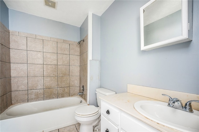 full bathroom with vanity, tiled shower / bath, tile patterned floors, and toilet