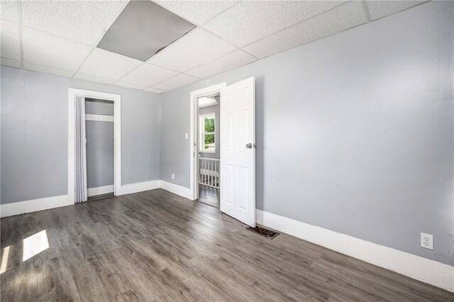 spare room featuring hardwood / wood-style flooring and a drop ceiling