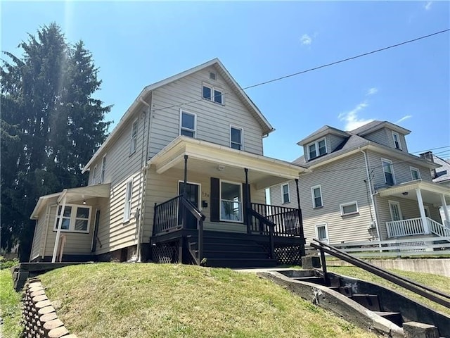 front of property with covered porch and a front yard