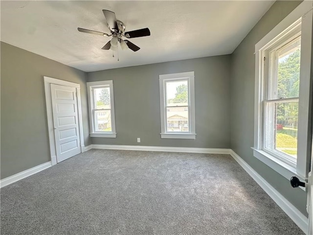 empty room with ceiling fan, carpet, and a healthy amount of sunlight