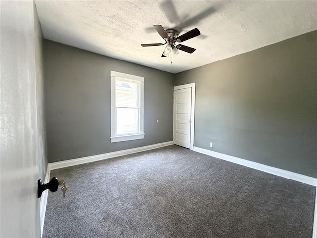 spare room with carpet, ceiling fan, and a textured ceiling