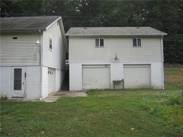 rear view of property featuring a lawn and an attached garage