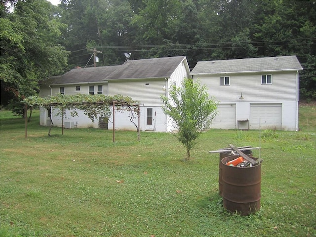 rear view of house featuring a yard and an attached garage