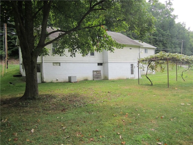 view of side of property featuring cooling unit and a lawn