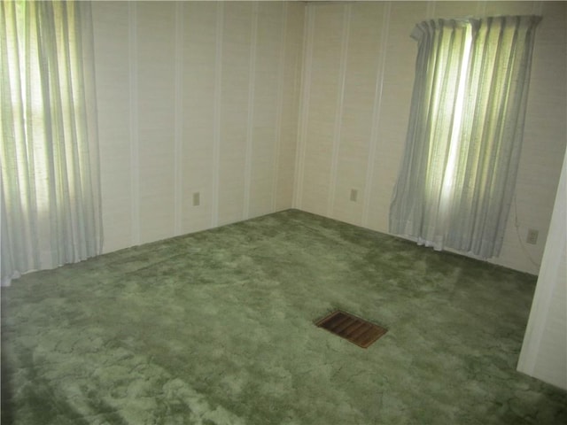 carpeted spare room featuring visible vents