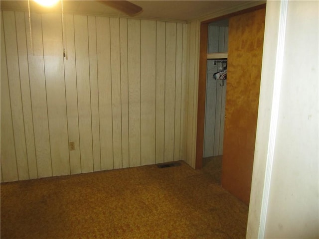 interior space featuring wood walls and carpet