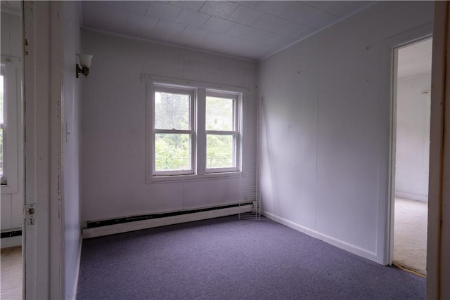 carpeted spare room featuring a baseboard heating unit