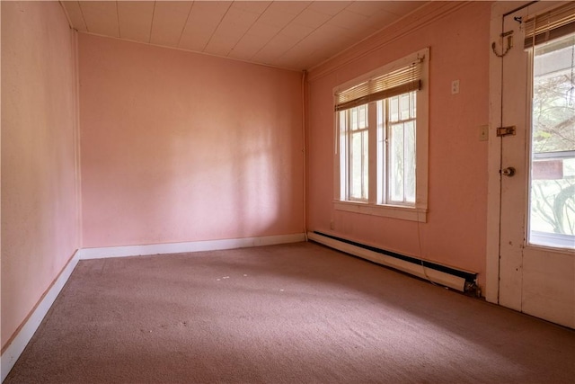 unfurnished room featuring plenty of natural light, carpet floors, and a baseboard heating unit