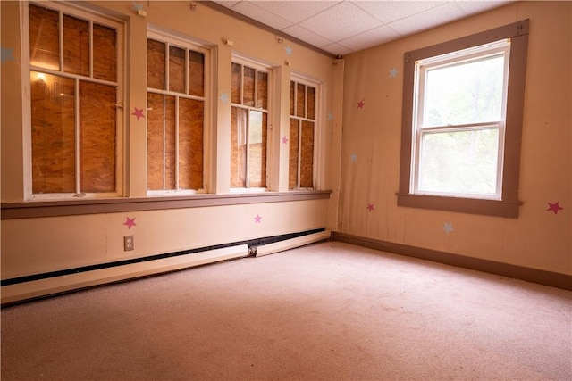 spare room featuring a paneled ceiling, carpet, and a baseboard heating unit