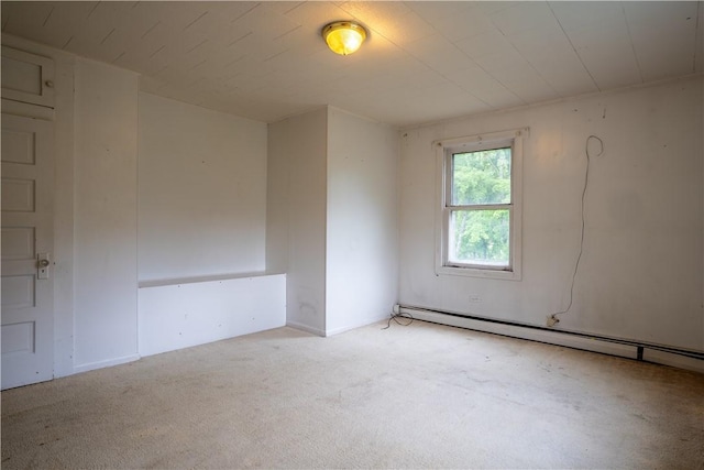 spare room featuring baseboard heating and light carpet