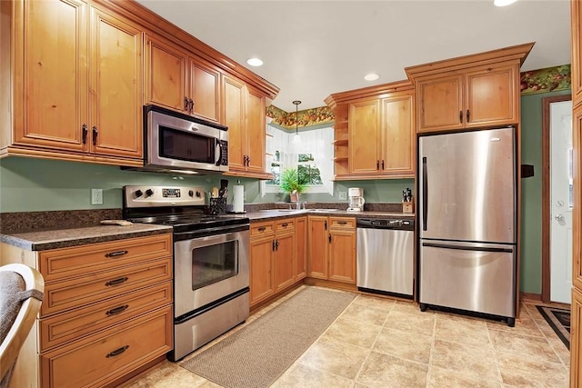 kitchen with sink, decorative light fixtures, and appliances with stainless steel finishes