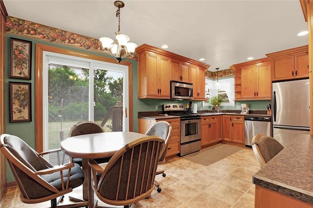 kitchen with decorative light fixtures, appliances with stainless steel finishes, and a chandelier