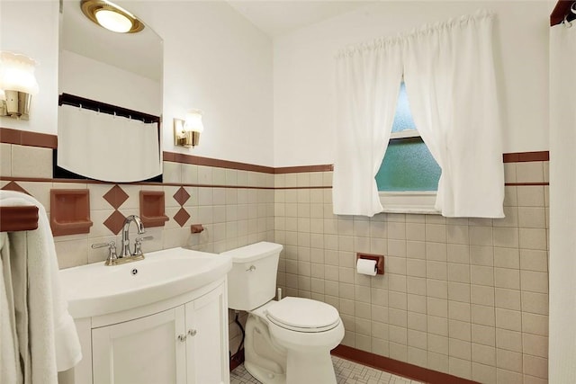 bathroom featuring tile walls, toilet, and vanity