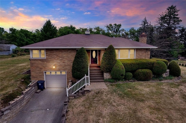 single story home with a garage and a lawn