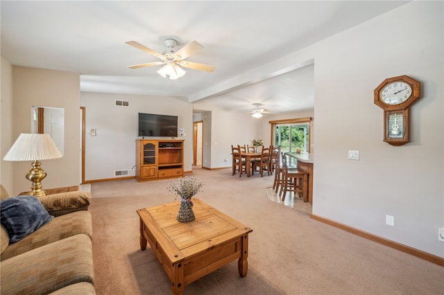 carpeted living room featuring beamed ceiling and ceiling fan